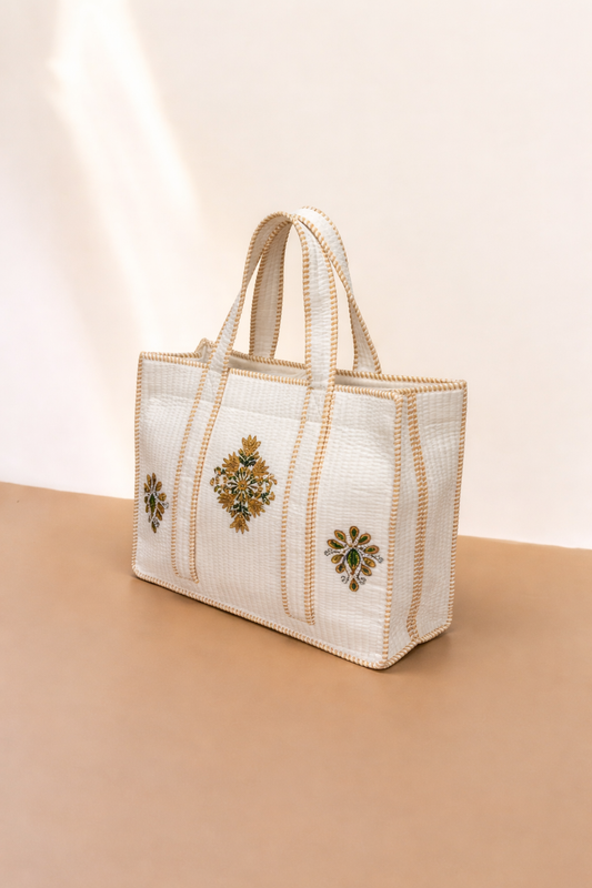 White handbag with decorative elements on a beige background