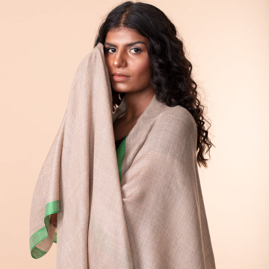 A woman draped in a gray and green