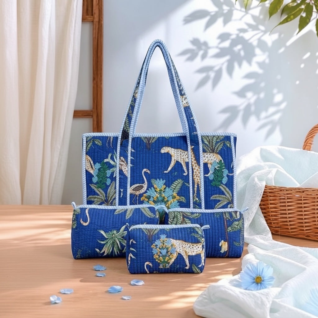 A matching fabric tote bag set with a blue tropical print featuring leopards, flamingos, and palm leaves, styled on a wooden table with soft white drapery and leaf shadows.