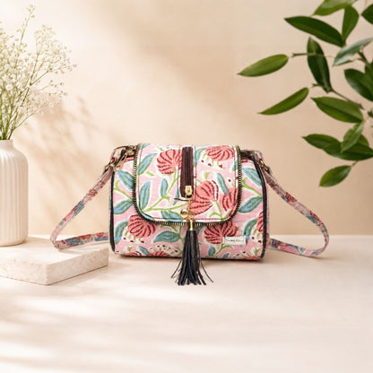 Floral patterned handbag with tassel on a light surface with a neutral background