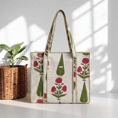 Tote bag with floral and geometric pattern on a white surface with a plant in the background