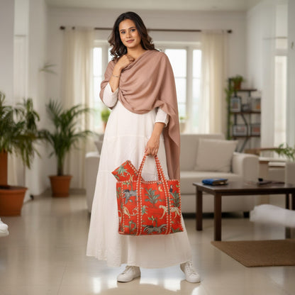 Woman holding a red patterned bag in a living room setting