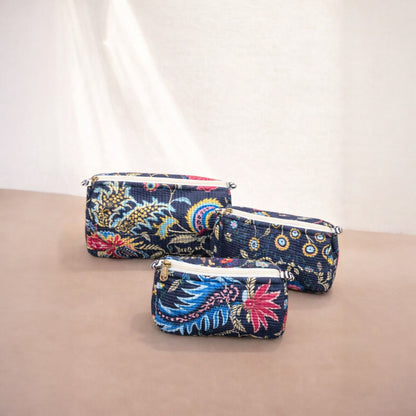 Three floral-patterned pouches on a beige surface with a white background