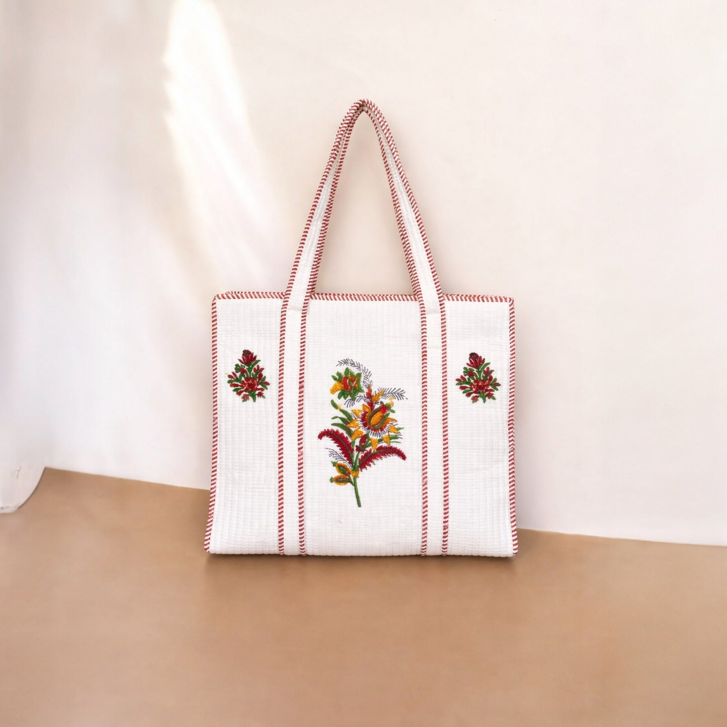 Tote bag with floral embroidery on a beige surface