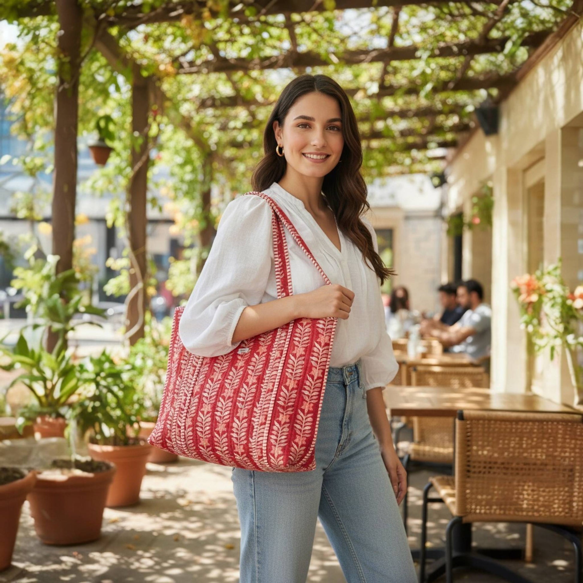 Woman holding a red and white patterned bag in an outdoor setting