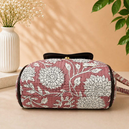 Floral-patterned cosmetic bag on a beige surface with a soft focus background