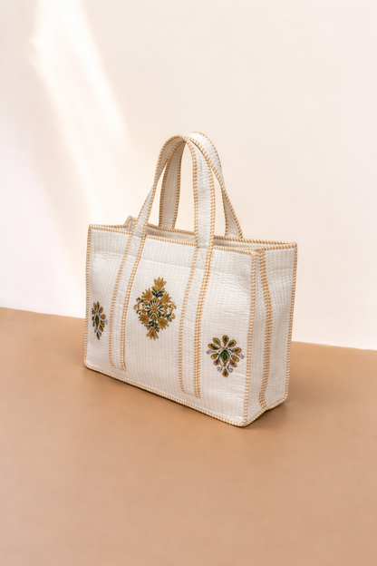 White handbag with decorative elements on a beige background