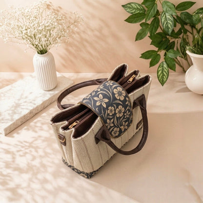 Handbag with floral pattern on a light surface with plants in the background