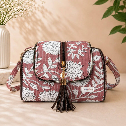 Floral patterned handbag with tassel on a beige surface