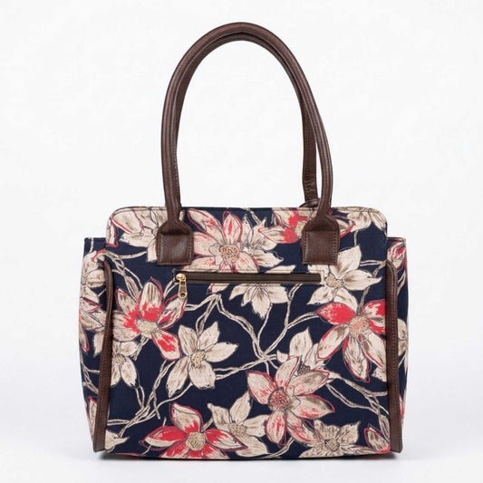 A structured tote handbag with a navy blue floral print, brown leather handles and trim, and a gold zipper on a plain white background.