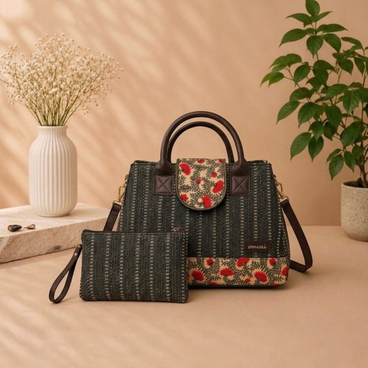 Black structured handbag featuring a green & red floral pattern on the flap & base