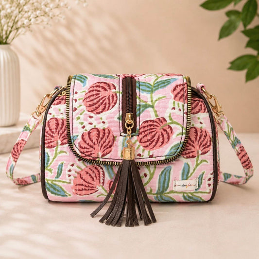 Floral patterned handbag with tassel on a light surface