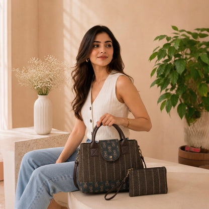 Woman holding a brown handbag in a home setting with plants and a vase.
