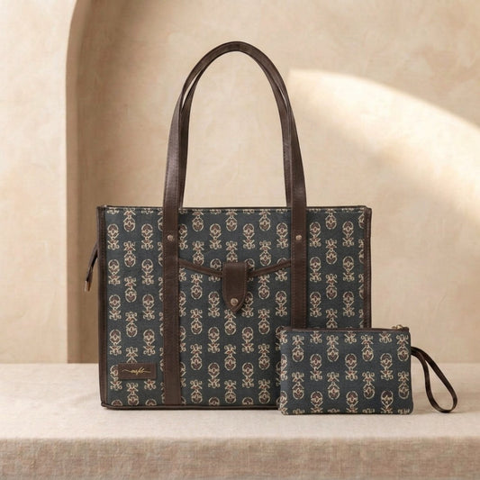 A dark green tote bag with a beige monogram pattern and brown leather handles, displayed next to a matching zip pouch on a beige stone surface.