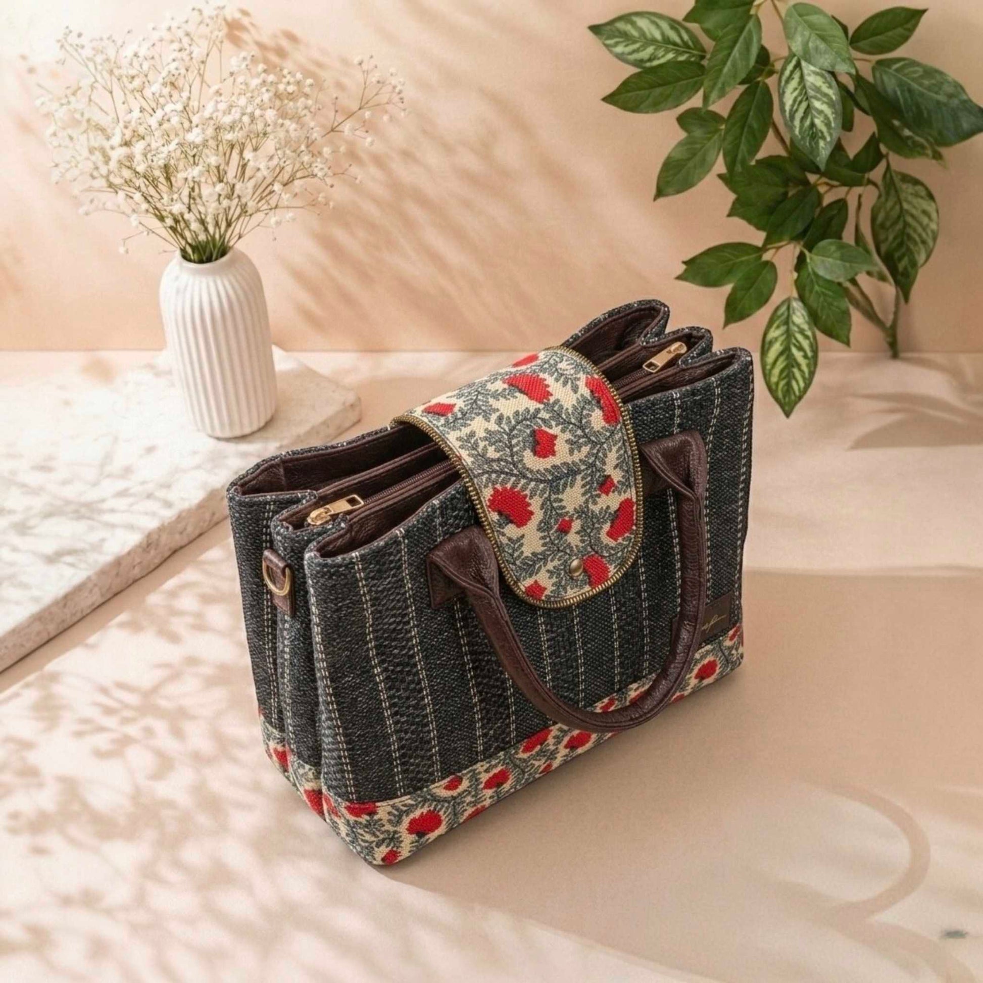 Handbag with floral pattern on a surface with plants in the background