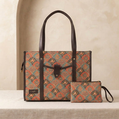 A patterned tote bag with dark brown handles and trim, shown alongside a matching zip pouch on a light beige surface against a warm beige background.