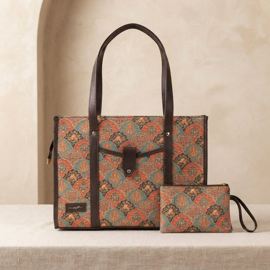 A patterned tote bag with dark brown handles and trim, shown alongside a matching zip pouch on a light beige surface against a warm beige background.