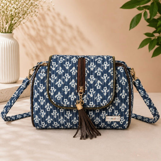 Blue patterned handbag with a tassel on a light surface with a neutral background